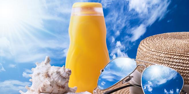 a bottle of sunscreen, a seashell, and a hat with a pair of sunglasses in the sand