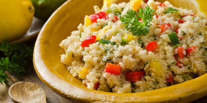 Bowl of quinoa salad with corn and chopped red pepper.