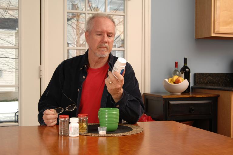 a retired man reading his supplement bottle